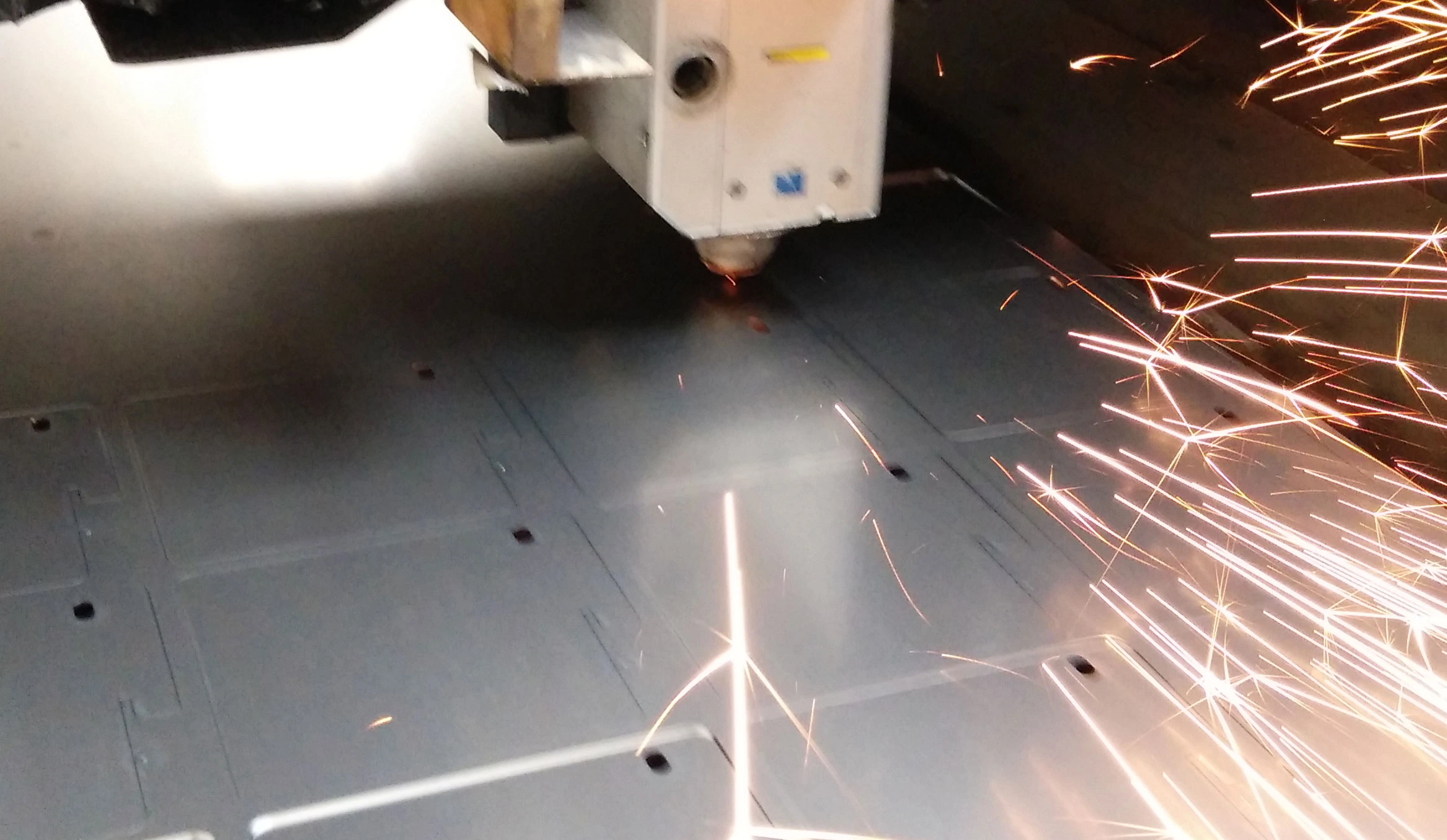 Laserska glava reže metalnu ploču uz snop iskri